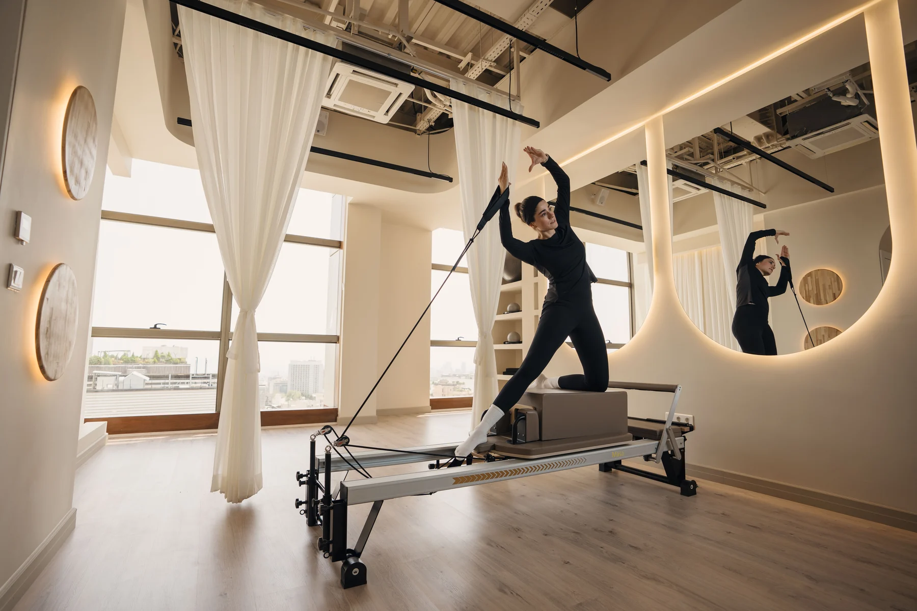 Estúdio amplo com equipamento reformer e praticante de Pilates